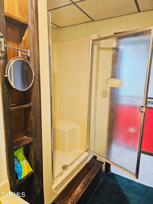 full bath featuring a drop ceiling and a shower stall