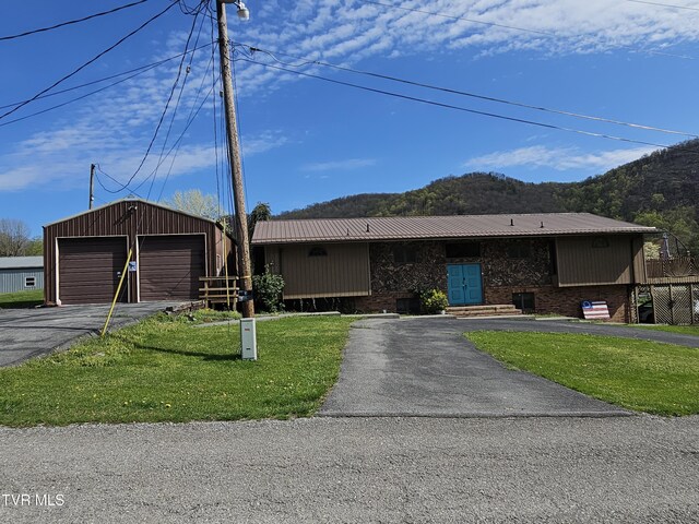 316 W Shawnee Ave, Big Stone Gap, VA 24219 - ranch-style home with a front lawn, an outbuilding, a mountain view, driveway, and metal roof