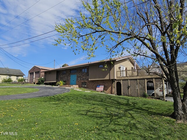 316 W Shawnee Ave, Big Stone Gap, VA 24219 - view of front facade with brick siding, a front lawn, and a wooden deck