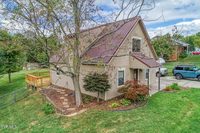 view of side of home featuring metal roof, a yard, a wooden deck, and fence