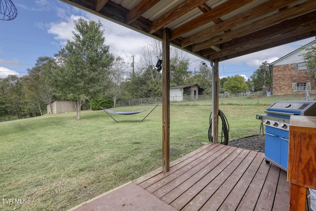 deck featuring a grill, a fenced backyard, and a yard