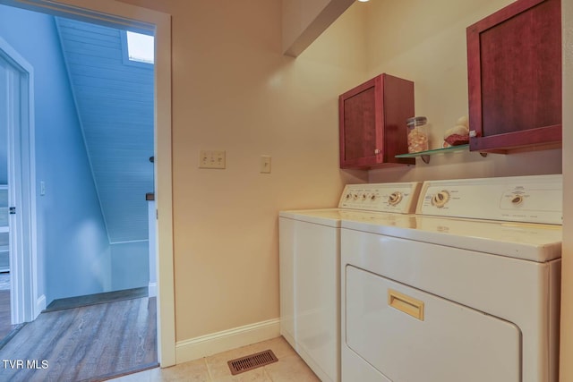 laundry area featuring visible vents, washer and clothes dryer, cabinet space, and baseboards