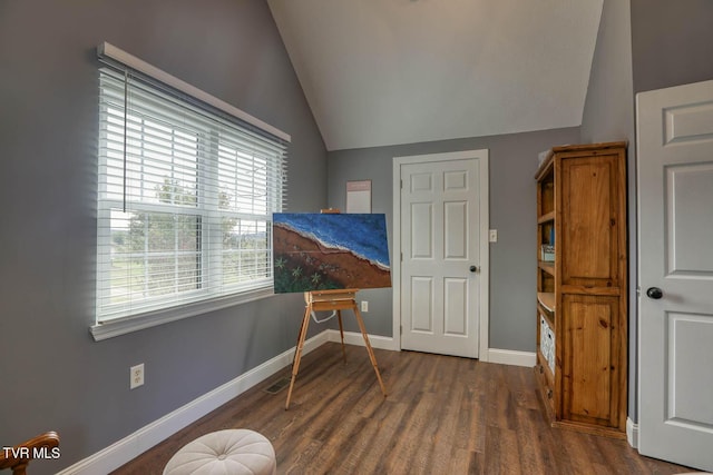 interior space with lofted ceiling, dark wood-style flooring, visible vents, and baseboards