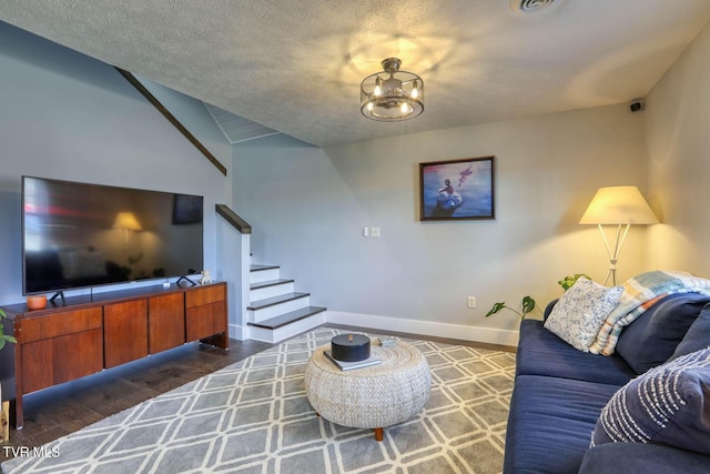 living room featuring dark wood-style flooring, a notable chandelier, stairway, a textured ceiling, and baseboards