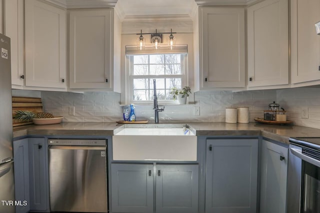 kitchen featuring appliances with stainless steel finishes, dark countertops, a sink, and tasteful backsplash