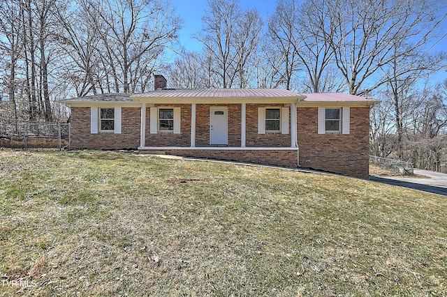 ranch-style house with a front yard, brick siding, and a chimney