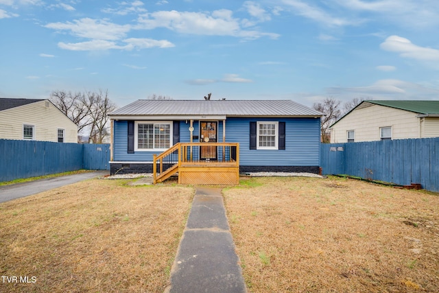 bungalow-style home featuring crawl space, fence private yard, metal roof, and a front lawn