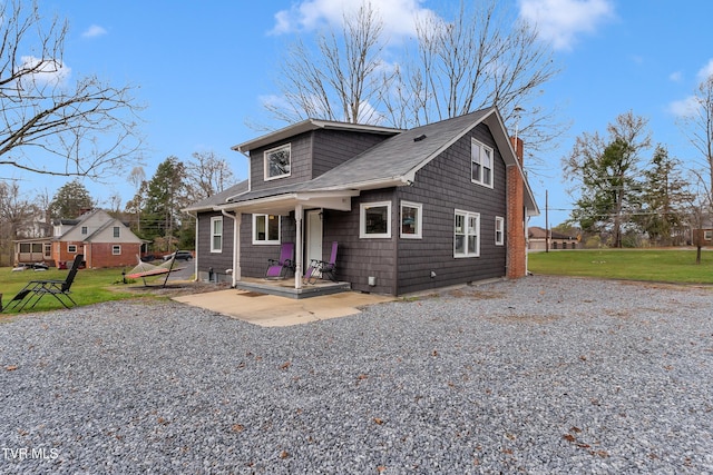 bungalow-style home featuring a front lawn and a patio area