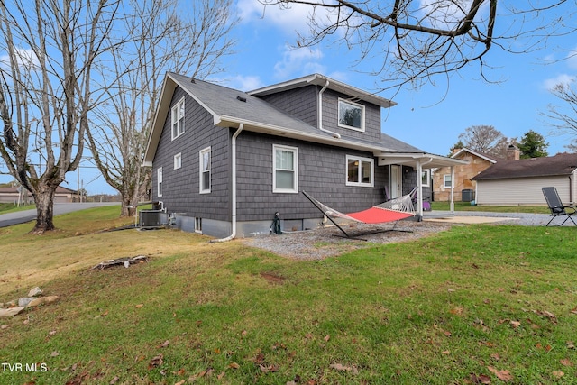 exterior space featuring central air condition unit, a lawn, and roof with shingles