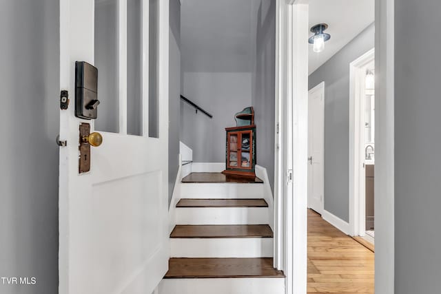 stairway featuring wood finished floors and baseboards