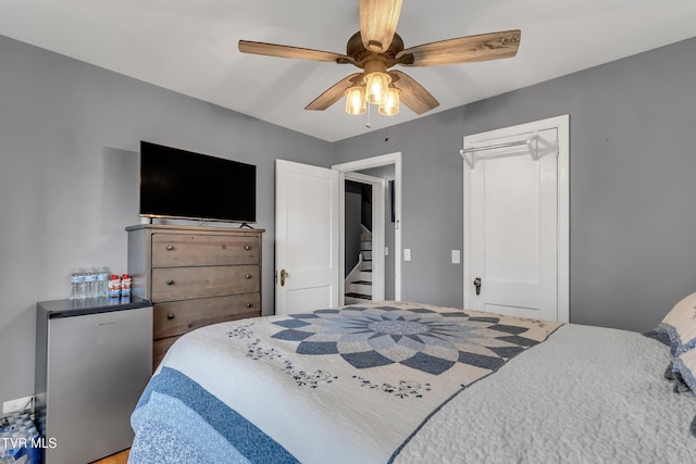 bedroom featuring freestanding refrigerator, a closet, and a ceiling fan