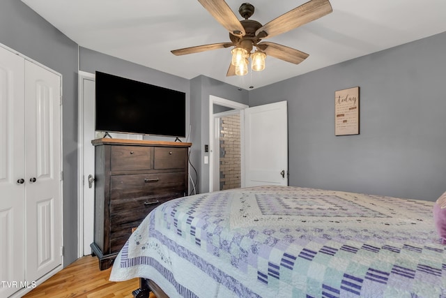 bedroom with light wood-type flooring, a closet, and a ceiling fan