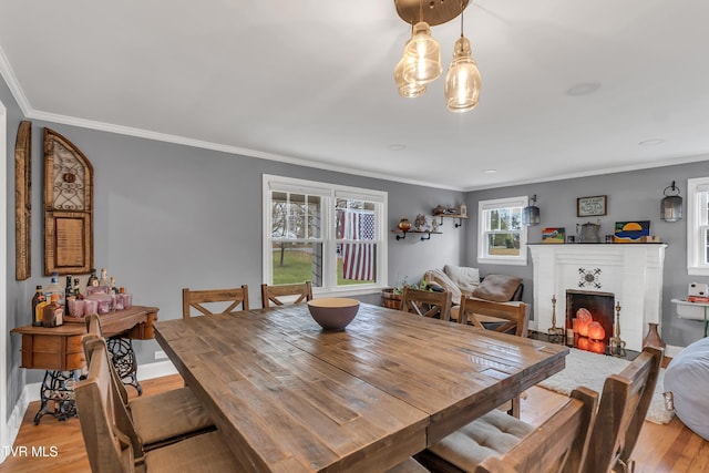 dining area featuring ornamental molding, light wood finished floors, a brick fireplace, and baseboards