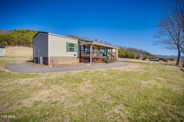 rear view of property with covered porch, a yard, and crawl space