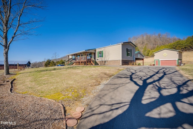 manufactured / mobile home with an outbuilding, stairway, and a front lawn