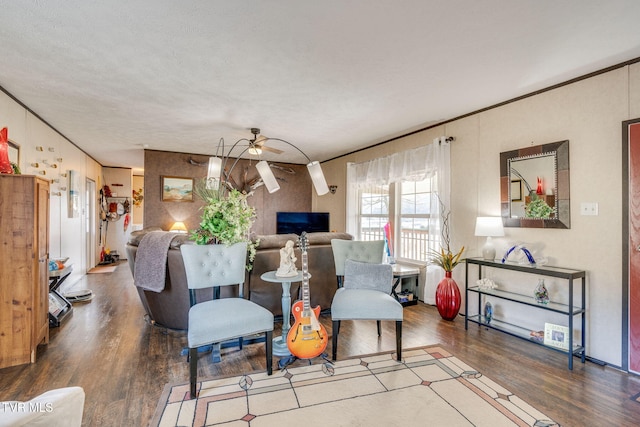 living room featuring a ceiling fan, crown molding, and wood finished floors