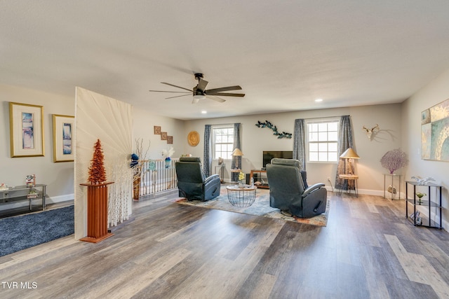 living area featuring ceiling fan, baseboards, and wood finished floors