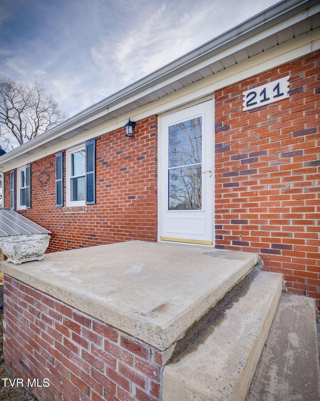 doorway to property with a patio and brick siding