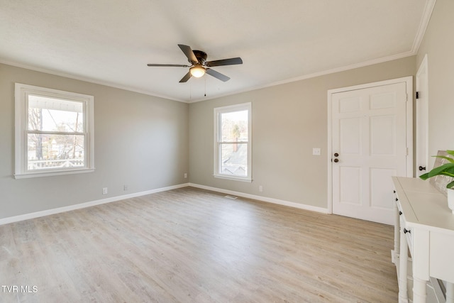 spare room with ceiling fan, light wood-style flooring, visible vents, baseboards, and crown molding