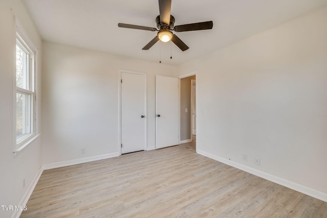 unfurnished room featuring light wood-style floors, baseboards, and a ceiling fan