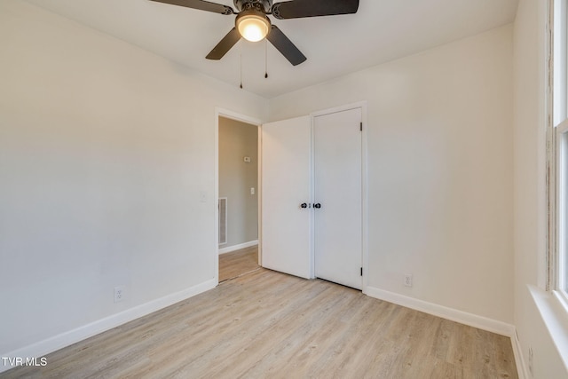 empty room featuring light wood-type flooring, visible vents, ceiling fan, and baseboards