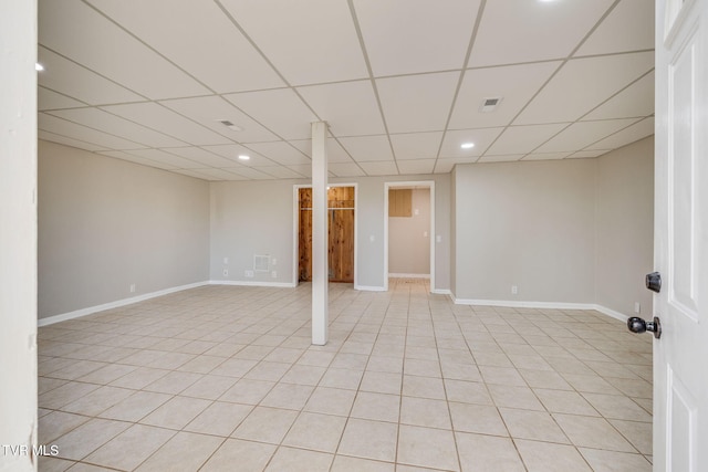 finished below grade area featuring baseboards, visible vents, a drop ceiling, and recessed lighting