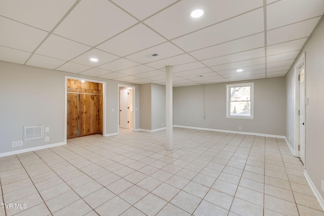 below grade area with recessed lighting, a drop ceiling, visible vents, and baseboards