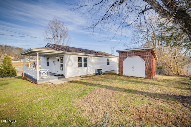 back of property with a porch, a lawn, a storage shed, cooling unit, and an outdoor structure