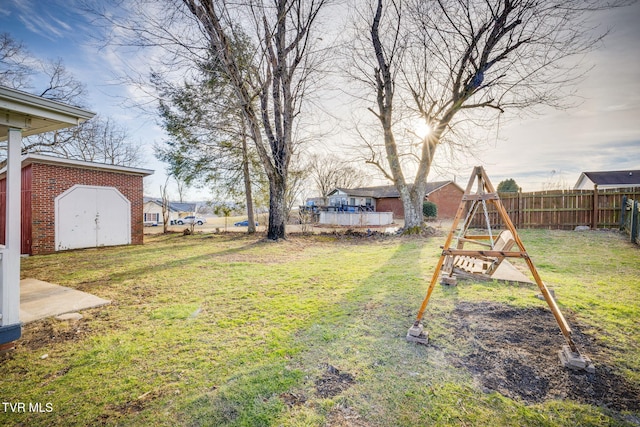 view of yard with a storage shed, an outdoor structure, and fence