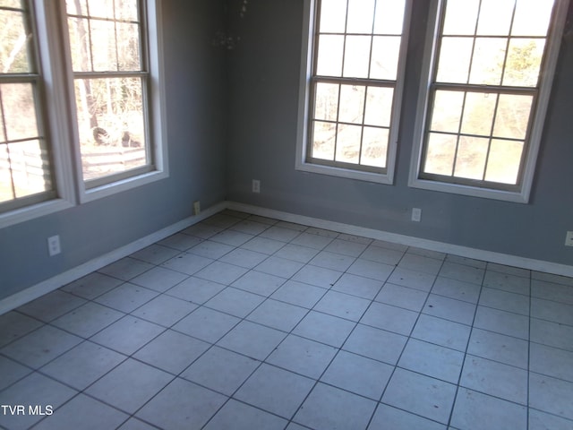 spare room featuring baseboards and a wealth of natural light