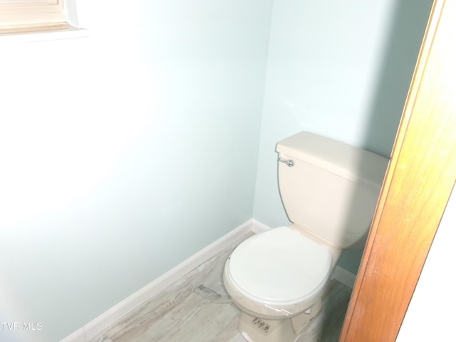 bathroom with baseboards and toilet