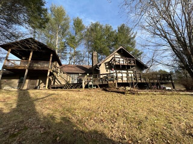 rear view of property featuring a chimney and a wooden deck