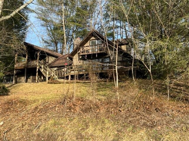 rear view of property featuring stairway and a deck