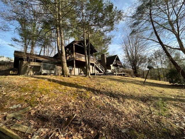 rear view of property featuring a deck and stairs