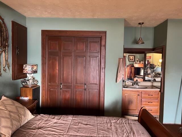 bedroom with a textured ceiling and a sink