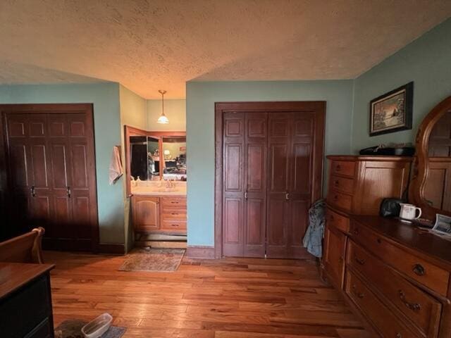 bedroom with light wood-style floors and a textured ceiling