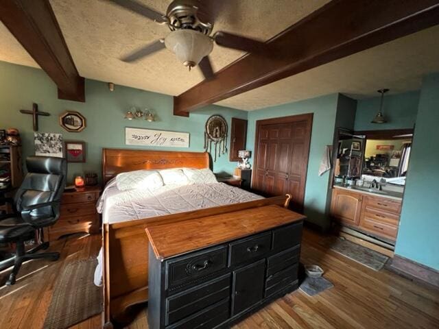 bedroom featuring dark wood-type flooring, beamed ceiling, a textured ceiling, and baseboard heating