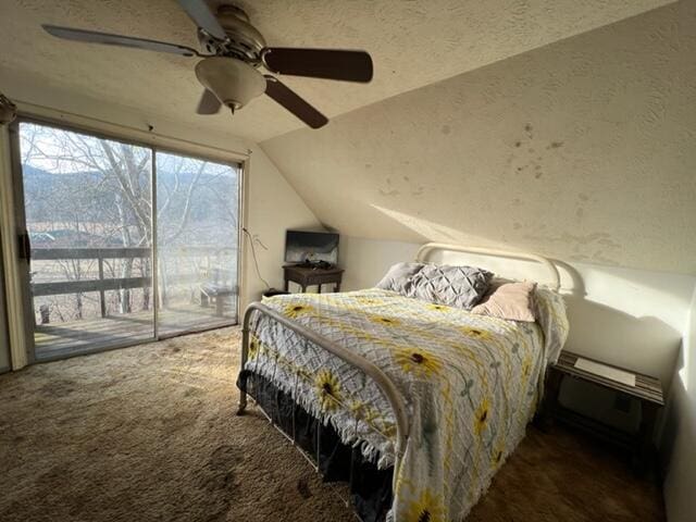 bedroom featuring a textured ceiling, carpet flooring, a ceiling fan, access to exterior, and vaulted ceiling