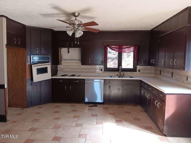 kitchen featuring oven, a sink, light countertops, stainless steel dishwasher, and decorative backsplash