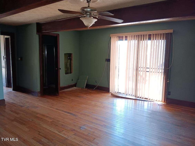 empty room featuring a ceiling fan, a textured ceiling, baseboards, and hardwood / wood-style flooring