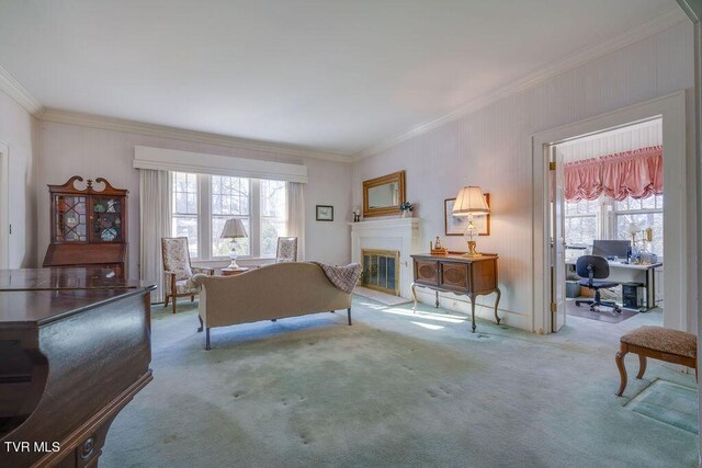 living area with light carpet, ornamental molding, and a glass covered fireplace