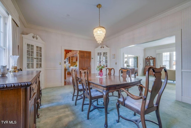 dining room with ornamental molding, light carpet, and an inviting chandelier