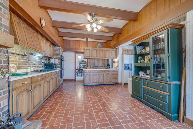 kitchen featuring brick floor, white refrigerator with ice dispenser, beam ceiling, light countertops, and dobule oven black