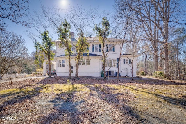 view of front of house with a chimney and central AC unit