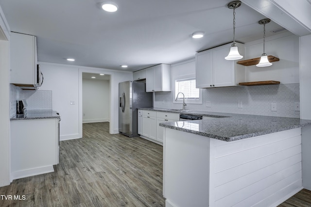 kitchen featuring a peninsula, dark countertops, open shelves, and white cabinetry