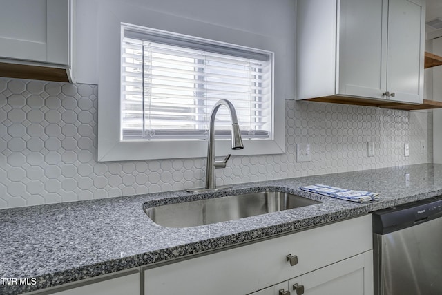 kitchen with a sink, tasteful backsplash, white cabinets, and dishwasher