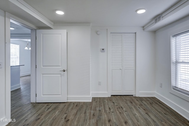 interior space featuring baseboards, a closet, visible vents, and dark wood-style flooring