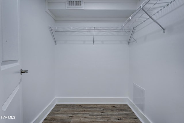 walk in closet with visible vents and dark wood finished floors