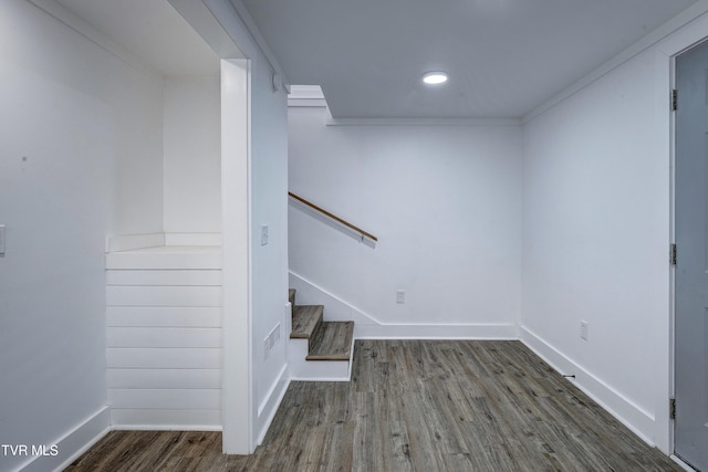 below grade area with baseboards, stairs, visible vents, and dark wood-style flooring