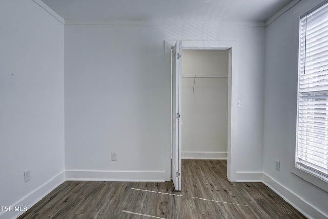 unfurnished room featuring baseboards, dark wood-style flooring, and a wealth of natural light